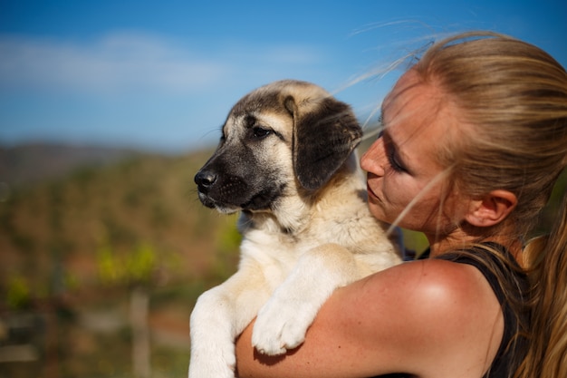 Chica rubia jugando con cachorro de mastín español