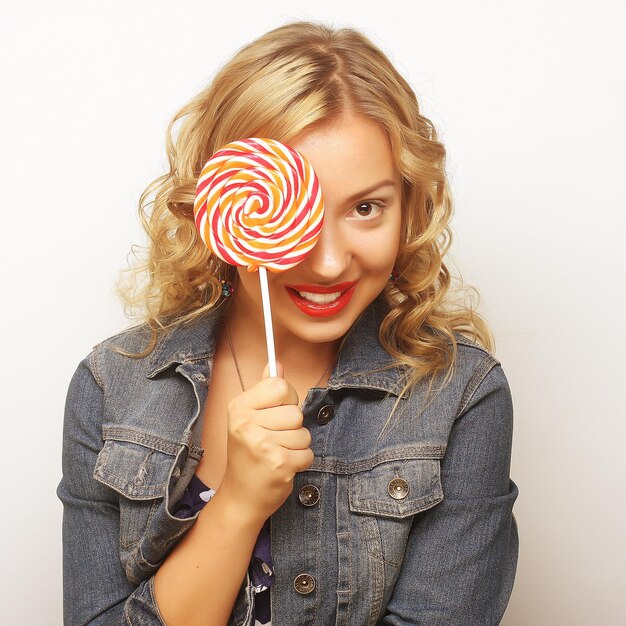 Foto una chica rubia con una piruleta.