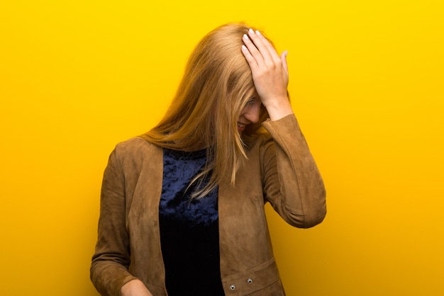 Chica rubia sobre fondo amarillo vibrante se ha dado cuenta de algo y tiene la intención de la solución