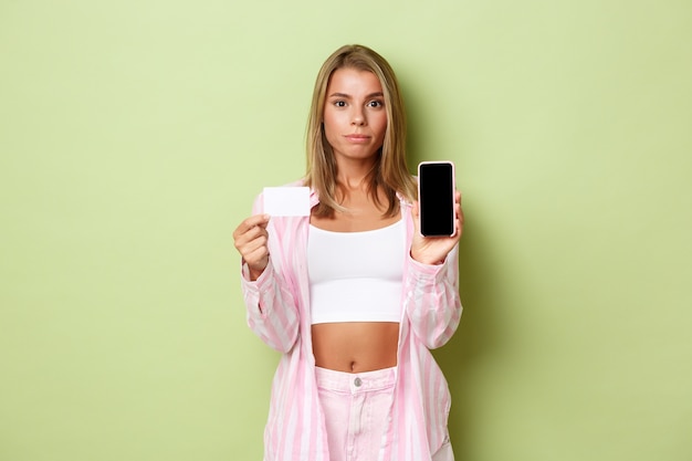 Chica rubia con un traje rosa posando