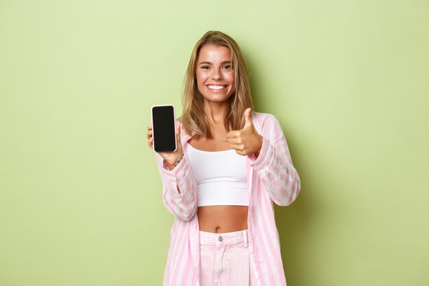 Chica rubia con un traje rosa posando