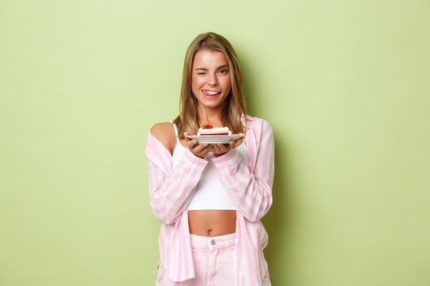 Chica rubia con un traje rosa posando