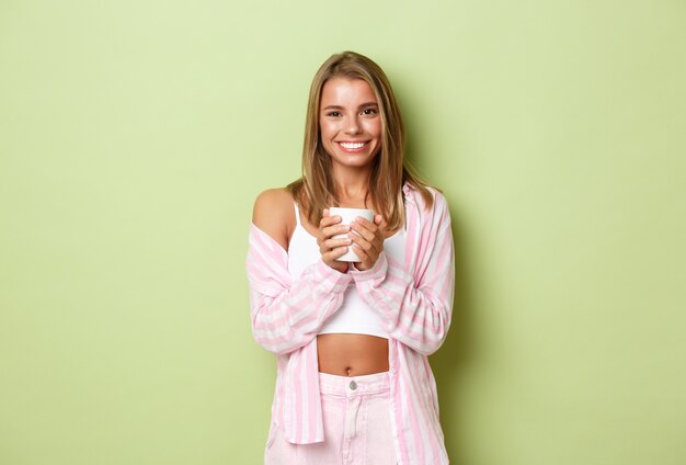 Chica rubia con un traje rosa posando