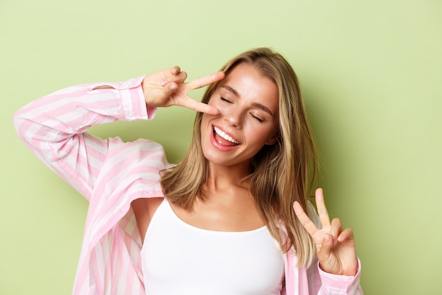 Chica rubia con un traje rosa posando