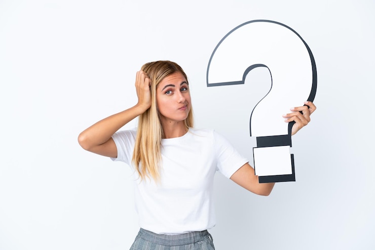 Foto chica rubia uruguaya aislada sobre fondo blanco sosteniendo un icono de signo de interrogación y tener dudas