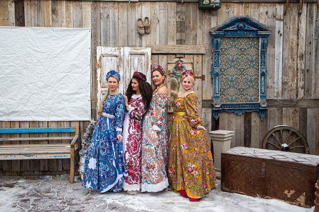 Chica rusa en trajes nacionales rusos de invierno en una aldea