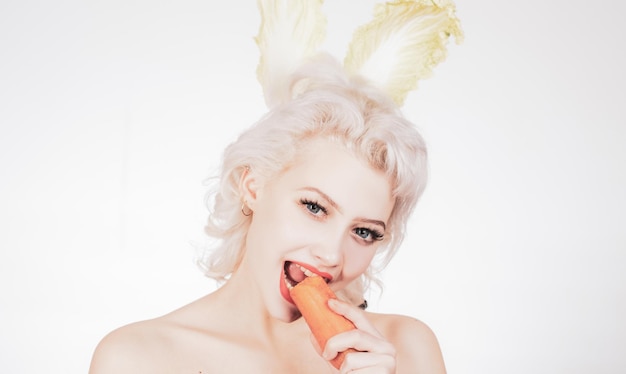 Chica sana con mordiscos una zanahoria como una liebre conejito de pascua vegano comiendo zanahoria saludable felices pascuas