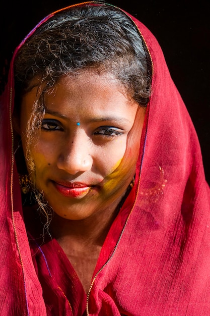 Una chica con un sari rojo en la cara.