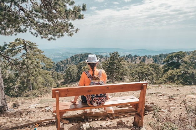 Chica sentada en el banco en la montaña de Troodos Chipre