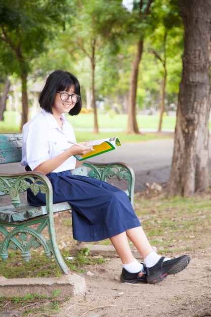 Chica sentada y leyendo un libro.