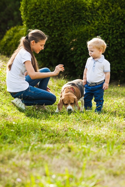 Chica sentada con perro beagle en la hierba