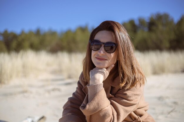 Chica sentada en la playa y disfruta del día de primavera