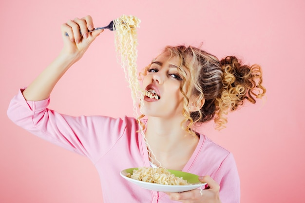 Foto chica sexy comiendo fideos desayuno por la mañana chica mantenga plato de espaguetis mujer atractiva comiendo