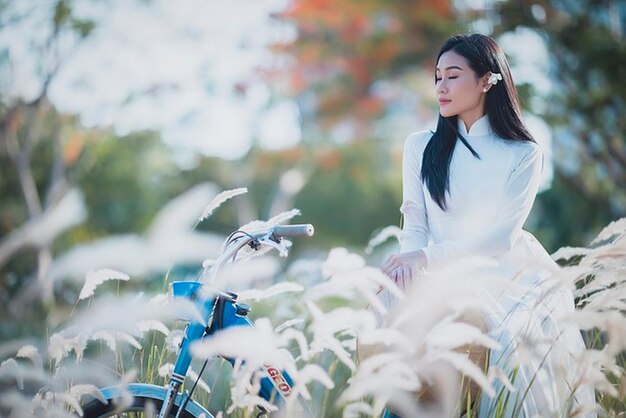 una chica se sienta en una bicicleta en un campo de flores