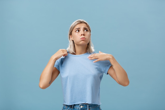 Chica siente malestar por el calor de pie sobre azul en fug exhalando