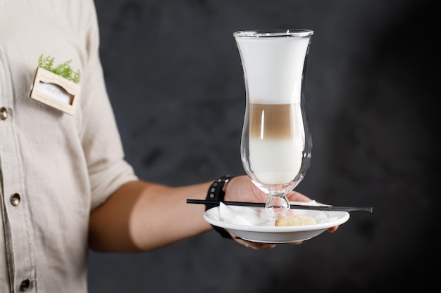 chica sirviendo café con leche y capuchino en un hermoso vaso transparente