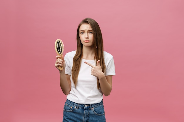 Chica sobre un fondo rosa con un peine para el cabello