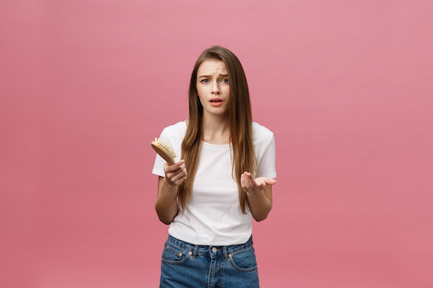 Chica sobre un fondo rosa con un peine para el cabello