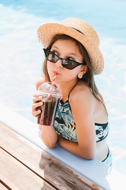 Foto chica con sombrero bebiendo un batido