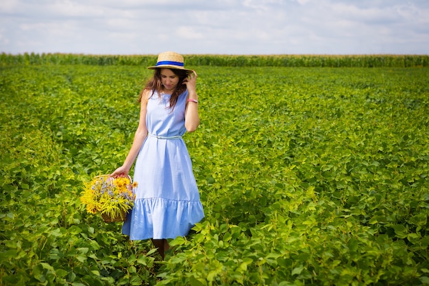 Chica con sombrero camina en el campo