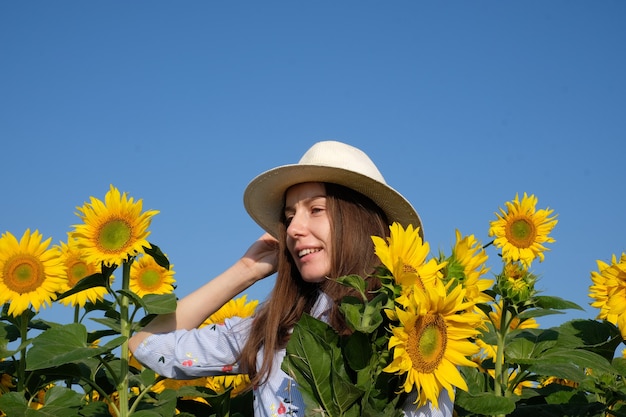 Chica con sombrero en el campo de girasoles