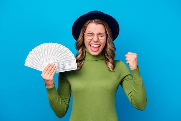 chica con sombrero y gafas sosteniendo abanico de dinero