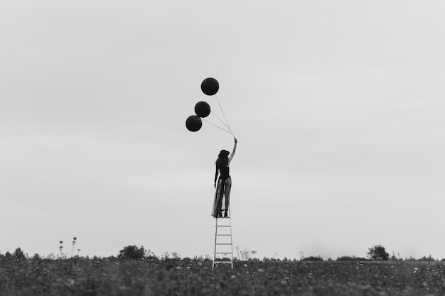 Chica con sombrero con globos en la mano