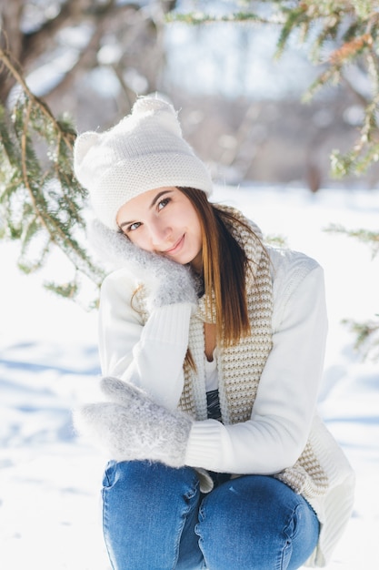 Chica con sombrero y guantes sonriendo en el invierno