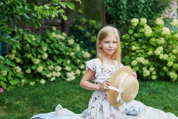 Chica con un sombrero en el jardín en un picnic