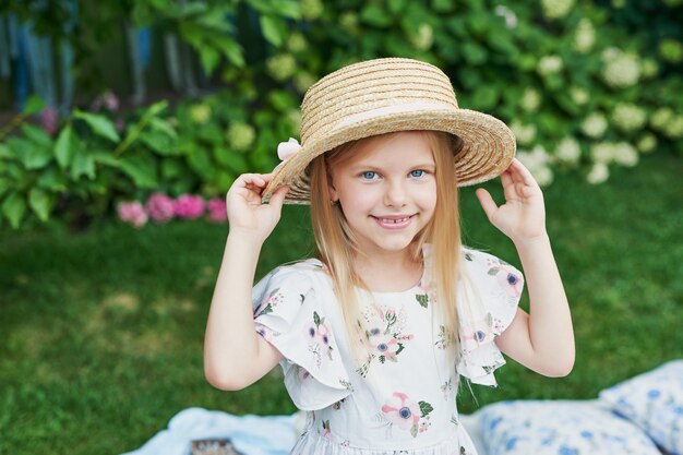 Chica con un sombrero en el jardín en un picnic