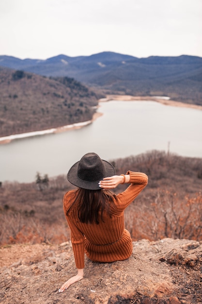 Foto la chica del sombrero mira el lago.