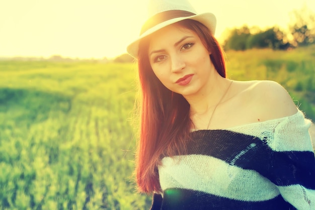 Chica con sombrero moda campo puesta de sol