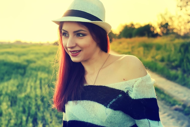 Chica con sombrero moda campo puesta de sol