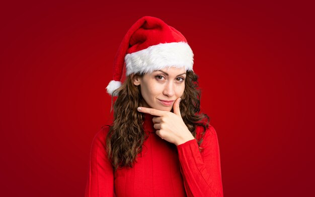 Chica con sombrero de navidad pensando en una idea