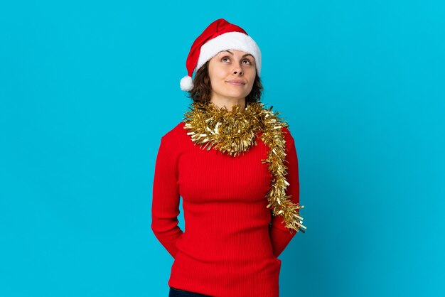 Chica con sombrero de Navidad sobre un fondo azul.