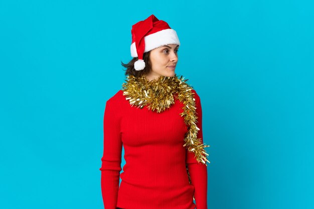 Chica con sombrero de Navidad sobre un fondo azul.