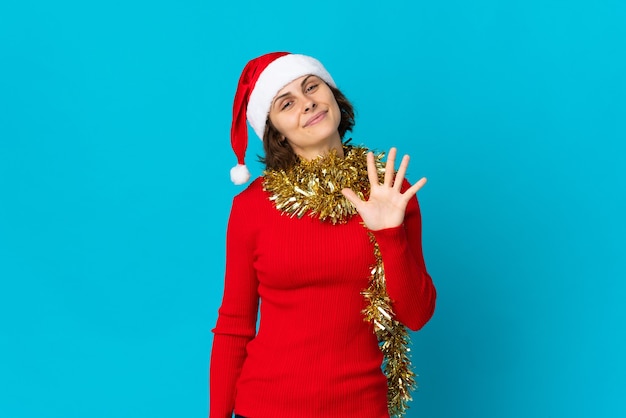 Chica con sombrero de Navidad sobre un fondo azul.