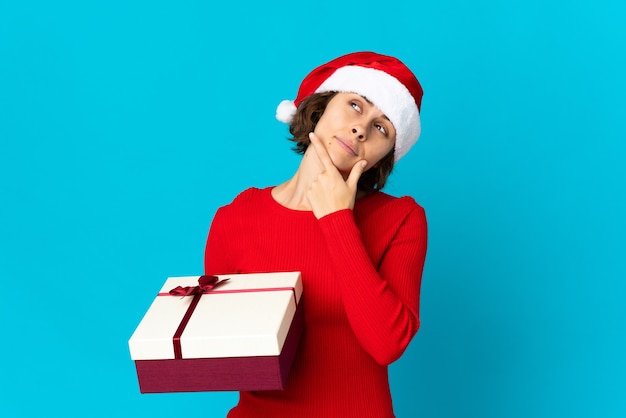 Chica con sombrero de Navidad sobre un fondo azul.