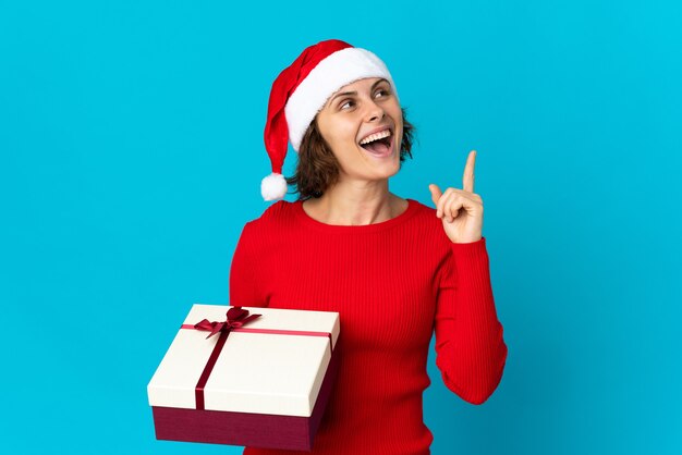 Chica con sombrero de Navidad sobre un fondo azul.