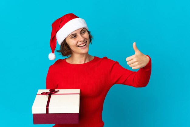 Chica con sombrero de Navidad sobre un fondo azul.