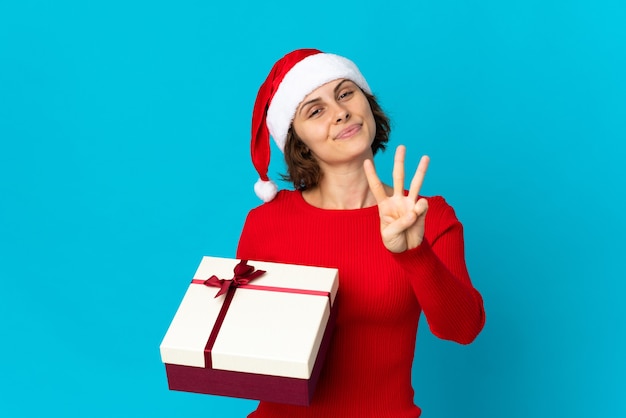 Chica con sombrero de Navidad sobre un fondo azul.