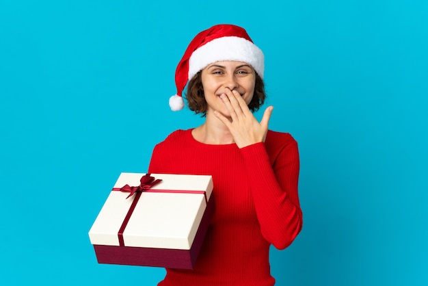 Chica con sombrero de Navidad sobre un fondo azul.