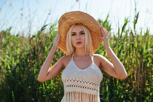 Chica con sombrero en la orilla de un estanque