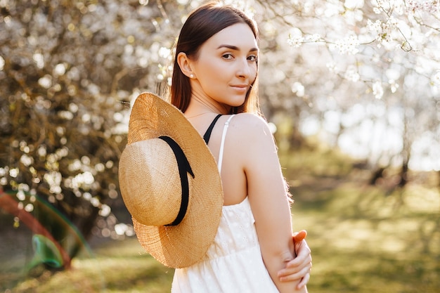 Chica con sombrero de paja en la primavera en el parque