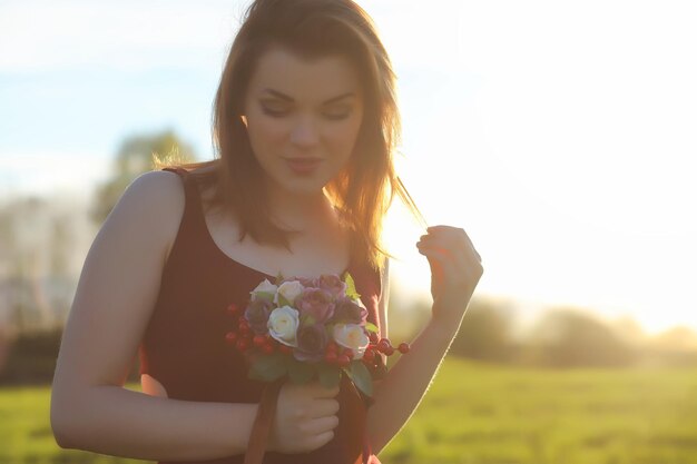 Una chica con sombrero en un paseo por el parque. Una niña con una canasta camina en la primavera. Chica camina por la carretera al atardecer.