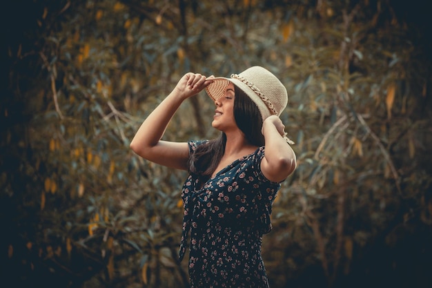 Chica con sombrero posando en el fondo de la naturaleza