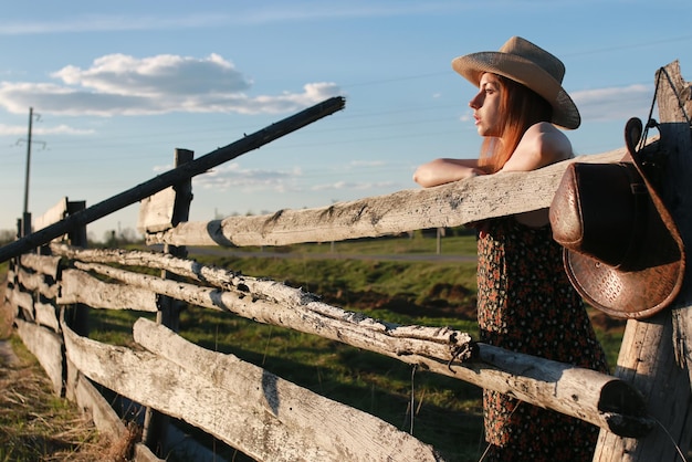 Chica en un sombrero de vaquero en un campo