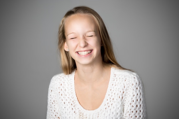 Chica sonriendo con los ojos cerrados