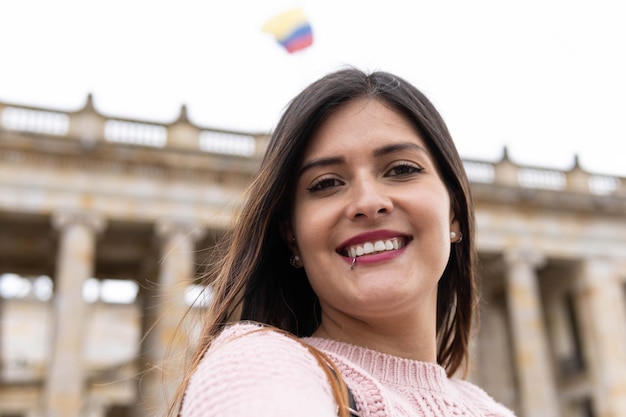 Chica sonriendo tomando un selfie en la ciudad de bogotá en colombia