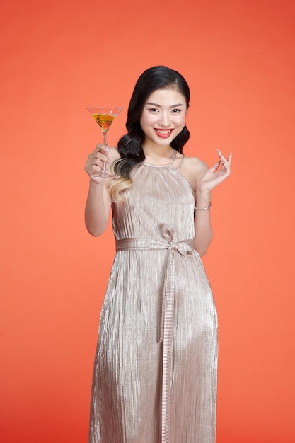 Chica sonriente feliz en elegante vestido glamoroso con copa de champán